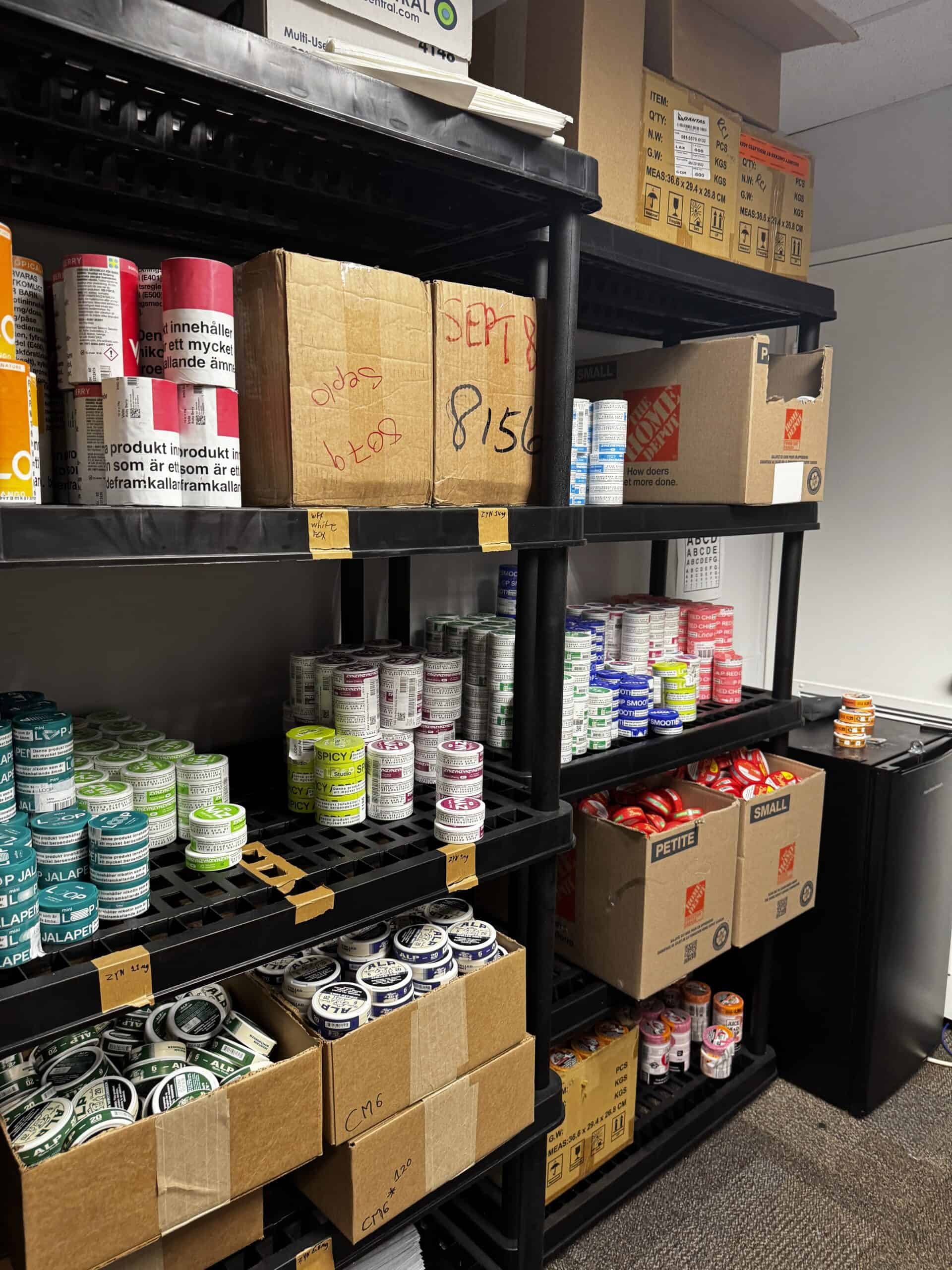 Shelves stocked with nicotine pouch products and shipping supplies